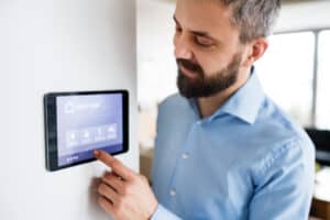 Man pointing to tablet mounted to wall