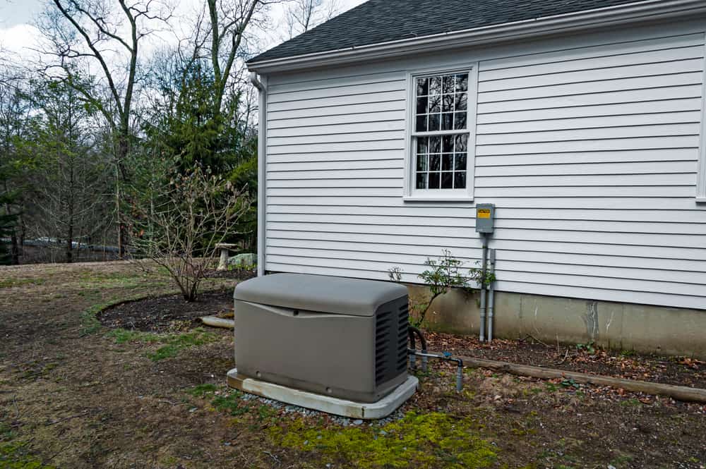 Residential standy generator installed on a concrete pad.