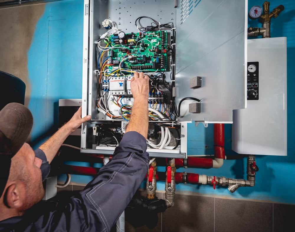 A person holding a wire in an electric control pannel